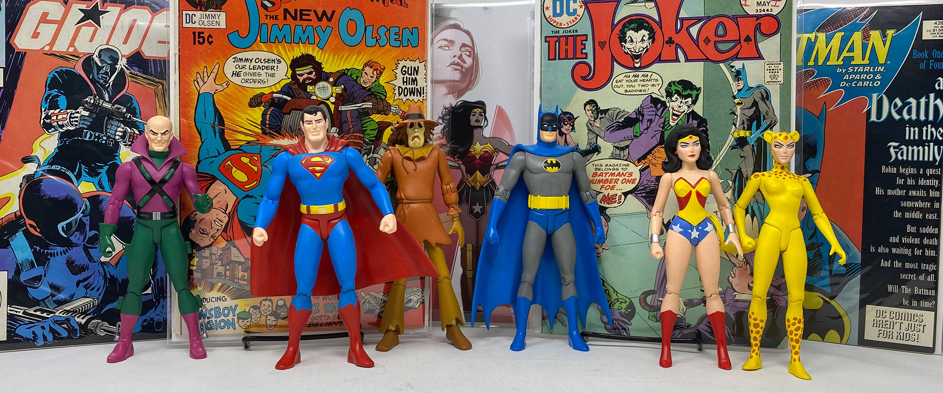 Image of Silver Age and Modern comics with some modern DC Comics action figures.